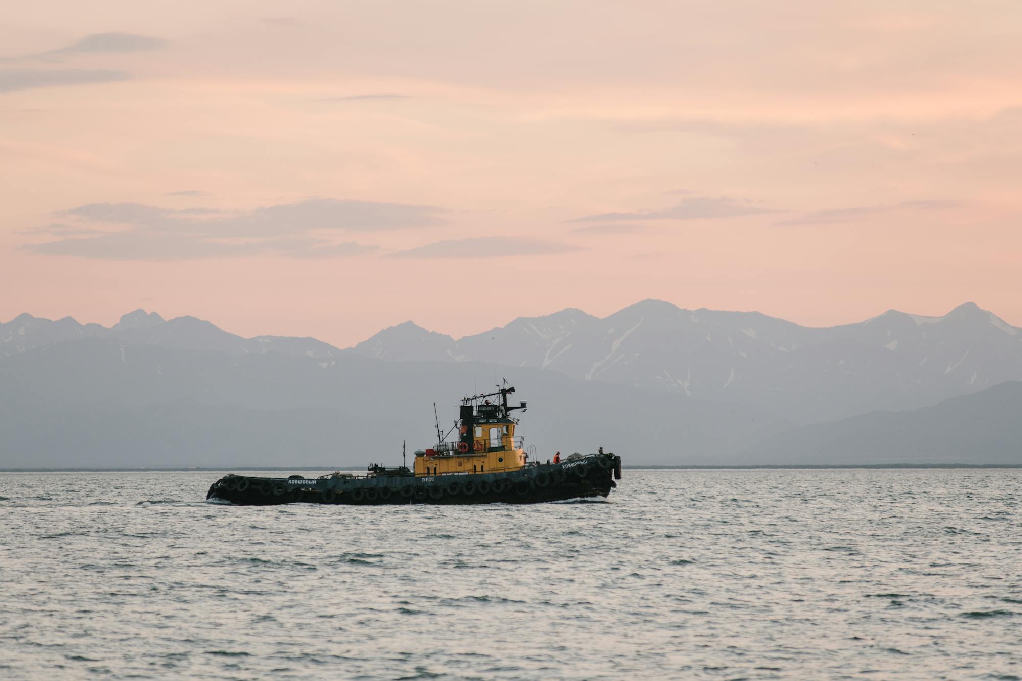A fishing boat on calm Alaskan water at golden hour